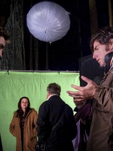 Robert Pattinson listens to directions from Chris Weitz as Kristen Stewart stands in the background behind the scenes of ‘New Moon,’ on April 23, 2009