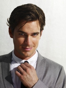 Matt Bomer fixes his tie in a ‘White Collar’ photo shoot