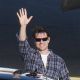Tom Cruise waves to photographers when arriving at the Salzburg airport in Austria