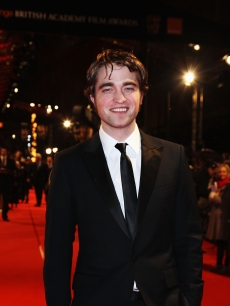 Robert Pattinson makes a smiling appearance on the red carpet at the BAFTA Awards in London, England, on February 21, 2010