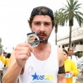 Shia LaBeouf shows his medal as he crosses the finish line of the 25th LA Marathon in Santa Monica, California on March 21, 2010

