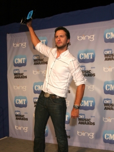 Luke Bryan, winner of Breakthrough Video of the Year, raises his trophy in triumph in the CMT Music Awards press room at the Bridgestone Arena in Nashville on June 9, 2010
