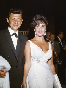 Elizabeth Taylor and her fourth husband American singer and actor Eddie Fisher arrive at a formal event, 1962