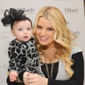 Jessica Simpson rocks her ruby engagement ring while holding a young fan at an in-store appearance at Dillard’s Oak Park in Overland Park, Kansas, on November 13, 2010  