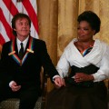 Oprah Winfrey and Paul McCartney listen to President Barack Obama as he gives a speech during the 2010 Kennedy Center Honorees to a reception in the East Room of the White House before going to the Kennedy Center in Washington, DC. on December 5, 2010 