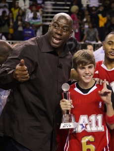 Justin Bieber and Magic Johnson celebrate at the 2011 BBVA NBA All-Star Celebrity Game at the Los Angeles Convention Center in LA on February 18, 2011 