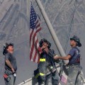 Firefighters raise a U.S. flag at the site of the World Trade Center after two hijacked commercial airliners were flown into the buildings on September 11, 2001 in New York City