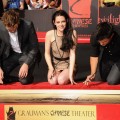 Kristen Stewart gives a smile as she, Robert Pattinson and Taylor Lautner get ready to put their hands in cement in front of Grauman’s Chinese Theatre on November 3, 2011 in Hollywood