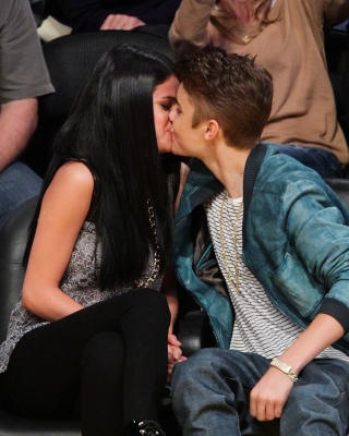 Pucker up! Selena Gomez and Justin Bieber kiss at a basketball game between the San Antonio Spurs and the Los Angeles Lakers at Staples Center in Los Angeles on April 17, 2012 