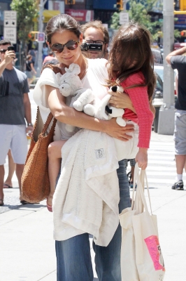 Katie Holmes gives a smile as she carries daughter Suri in New York City on July 8, 2012