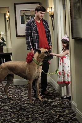 Walden (Ashton Kutcher, left) brings Zoey’s daughter, Ava (Talyan Wright, right) a surprise for her birthday, on ‘Two and a Half Men’