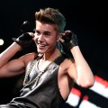 Justin Bieber shows off his guns while onstage during Hot 99.5’s Jingle Ball 2012 on December 11, 2012 in Washington, D.C. 