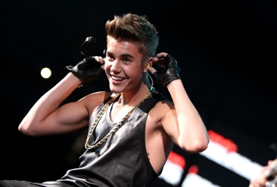 Justin Bieber shows off his guns while onstage during Hot 99.5’s Jingle Ball 2012 on December 11, 2012 in Washington, D.C. 