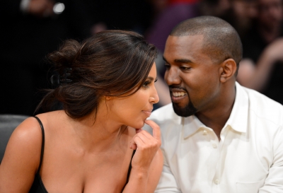 Kim Kardashian and rapper Kanye West talk from their courtside seats before the Los Angeles Lakers take on the Denver Nuggets in Game Seven of the Western Conference Quarterfinals in the 2012 NBA Playoffs on May 12, 2012 at Staples Center in Los Angeles
