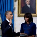 President Barack Obama takes the oath of office as first lady Michelle Obama holds the Bible in the Blue Room of the White House January 20, 2013 in Washington, DC