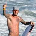 A shirtless David Beckham catches some waves in Malibu, Calif., on August 27, 2011
