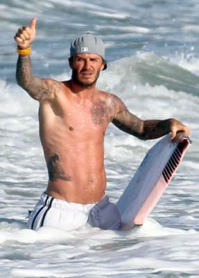 A shirtless David Beckham catches some waves in Malibu, Calif., on August 27, 2011