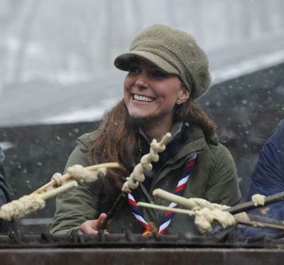 Catherine, Duchess of Cambridge cooks dough around a campfire at the Great Tower Scout camp on March 22, 2013 in Windermere, Cumbria, United Kingdom