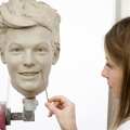 Madame Tussauds, sculptor Georgina Power works on the clay head of Louis Tomlinson of One Direction. Madame Tussauds announced on March 11, 2013 that the world famous wax attraction will immortalize the band by creating five individual wax figures of each member
