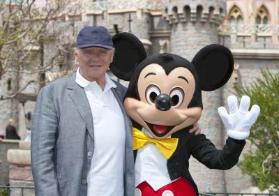 Sir Anthony Hopkins meets Mickey Mouse in front of Sleeping Beauty Castle at Disneyland park in Anaheim, Calif., on April 1, 2013