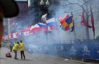 Officials react as the first explosion goes off on Boylston Street near the finish line of the 117th Boston Marathon on April 15, 2013
