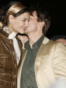 Tom Cruise whispers into Katie Holmes’ ear