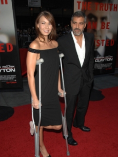 George Clooney escorts girlfriend Sarah Larson who is on crutches 