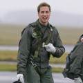 Prince William gestures as he walks across the airfield at the RAF Cranwell training school in Lincolnshire, England