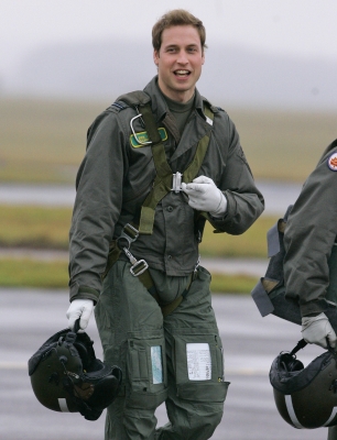 Prince William gestures as he walks across the airfield at the RAF Cranwell training school in Lincolnshire, England