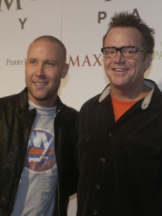 Michael Robinson & Tom Arnold chuckle as they enter the party