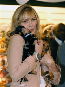 Kim Cattrall and miniature smooth coat dachshunds at the Harrods Summer Sale in Knightsbridge