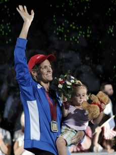 Dara Torres holds her daughter Tessa, 2, and waves to the crowd wearing her medal for the women’s 100-meter freestyle