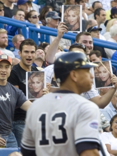 Fans hold up pictures of Madonna as Alex Rodriguez strikes out in Canada 