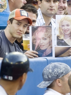 Fans hold up pictures of Madonna as Alex Rodriguez strikes out in Canada 