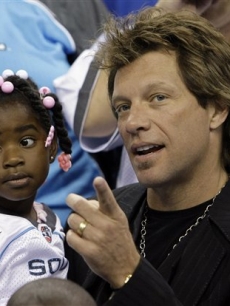Jon Bon Jovi and a fan catch the ArenaBowl XXII football game