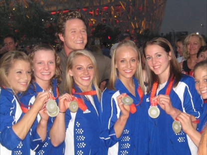 The women’s gymnasts show off their silver to Billy