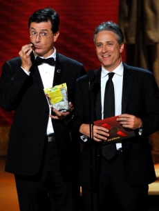 Stephen Colbert enjoys a snack while presenting with Jon Stewart