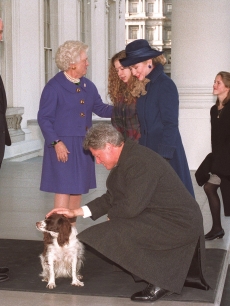 US President-elect Bill Clinton pets the Bush’s dog Millie as First Lady Barbara Bush greets Hillary Clinton