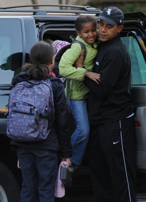 Barack hold Sasha as he drops the girls off at school