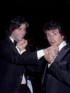 John Travolta and Sylvester Stallone exchange mock punches at the Dorothy Chandler Pavillion in Los Angeles, California, April 1978
