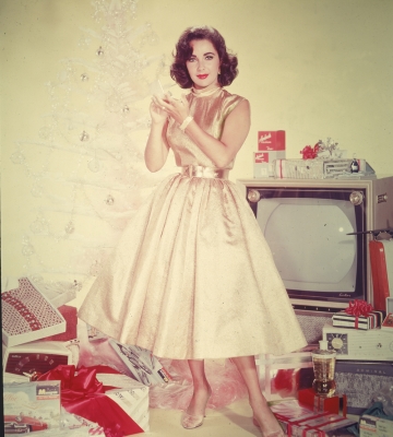 Elizabeth Taylor poses in front of an artificial tree, 1950s