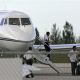 An unidentified crew member descends John Travolta’s private jet at Grand Bahama International Airport in Freeport, Grand Bahama, Bahamas