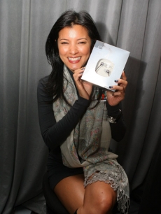 Kelly Hu holds up her Ultimate Ears by Logitech earphones