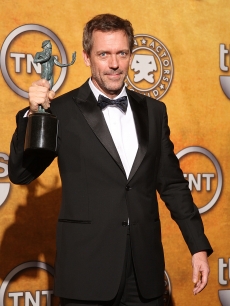 Hugh Laurie poses with his award for Outstanding Performance by a Male Actor backstage 