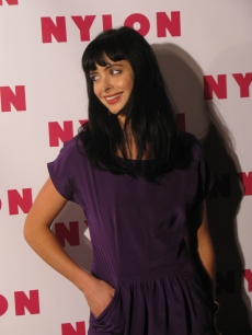 Krysten Ritter smiles on a Nylon party red carpet