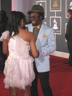 will.i.am shares a smile with a reporter on the red carpet at the Grammys