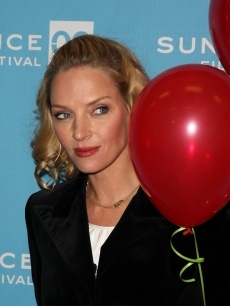 Uma Thurman hides behind some red balloons