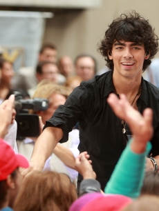 A curly haired, Joe Jonas greets fans on NBC’s ‘Today’ at Rockefeller Center on June 19, 2009 in New York City