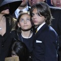 Blanket hugs a doll of his dad as he is comforted by sister Paris and brother Prince Michael I at the Michael Jackson public memorial, July 7, 2009